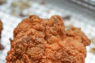 Crispy fried chicken thigh over a rack.jpg