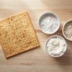 Single piece of matzah on a light wood surface.jpg